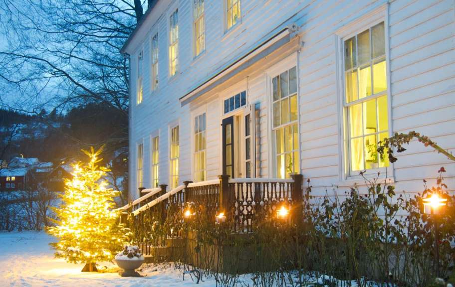 Ein weihnachtsbaum steht vor einem weißen haus