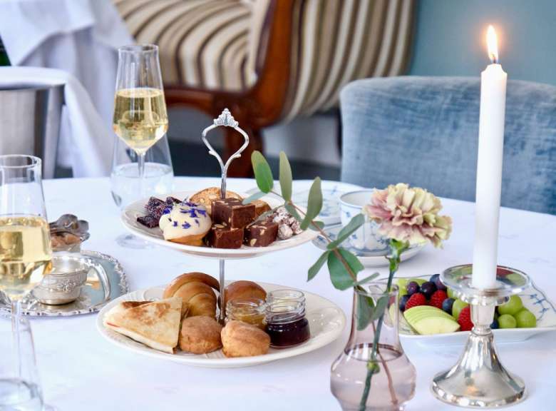 Auf einem tisch steht ein etagere mit desserts und kerzen