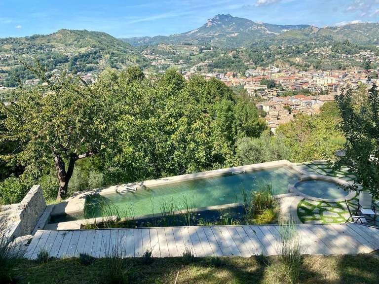 Ein Pool mit Blick auf eine Stadt mit Bergen im Hintergrund