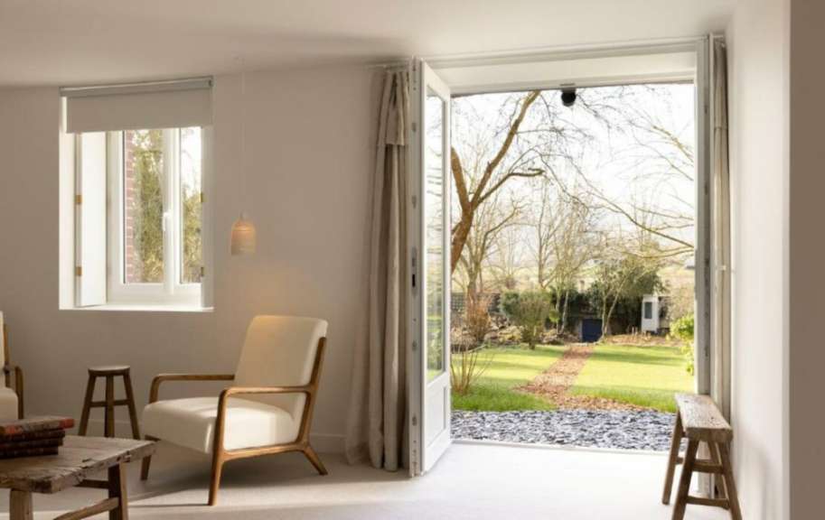 Ein Wohnzimmer mit einem Stuhl und einem Fenster mit Blick auf einen Garten