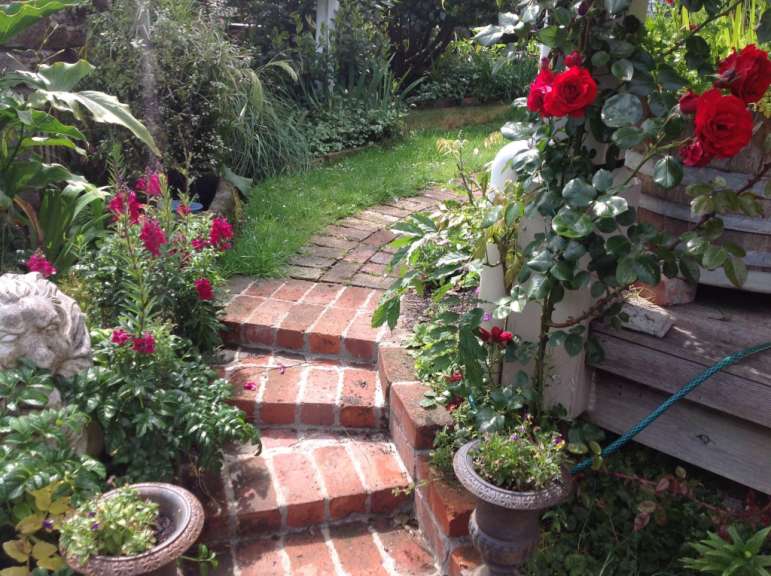 Ein Garten mit roten Rosen und einer Statue eines Löwen