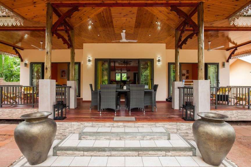 Ein Haus mit einem Tisch und Stühlen auf der Veranda