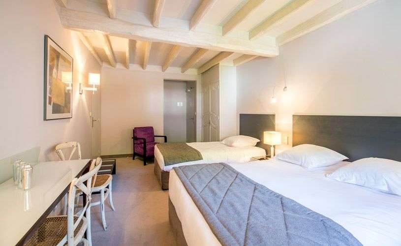 Ein Hotelzimmer mit zwei Betten und einem Schreibtisch