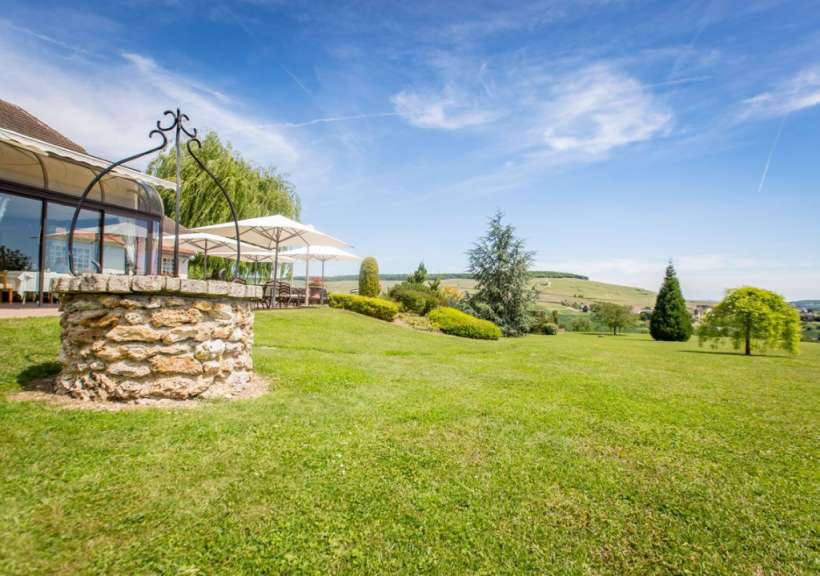 Ein Brunnen steht in der Mitte eines grünen Feldes