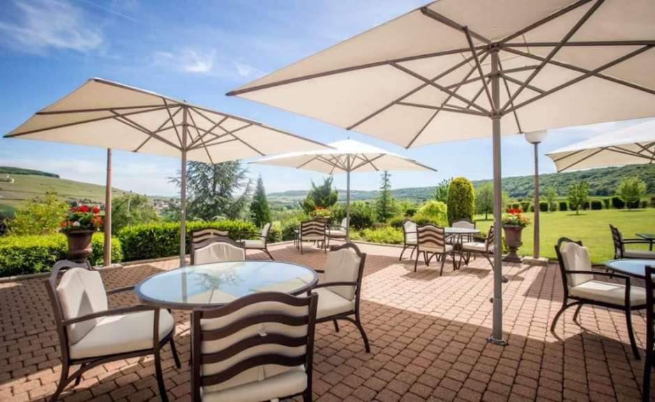 Eine Terrasse mit Tischen und Stühlen und vielen Sonnenschirmen