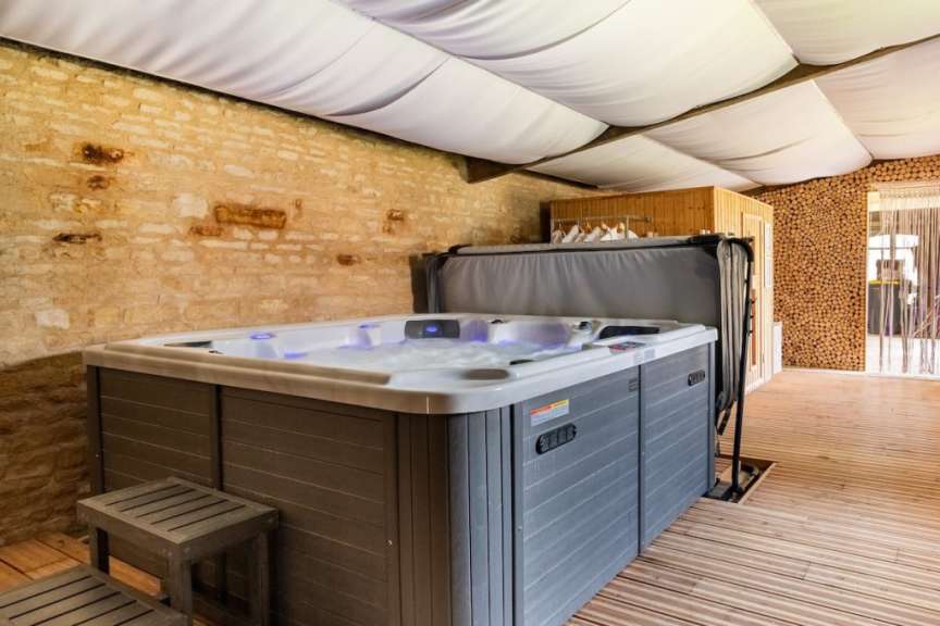 Ein grau-weißer Whirlpool steht auf einem Holzdeck