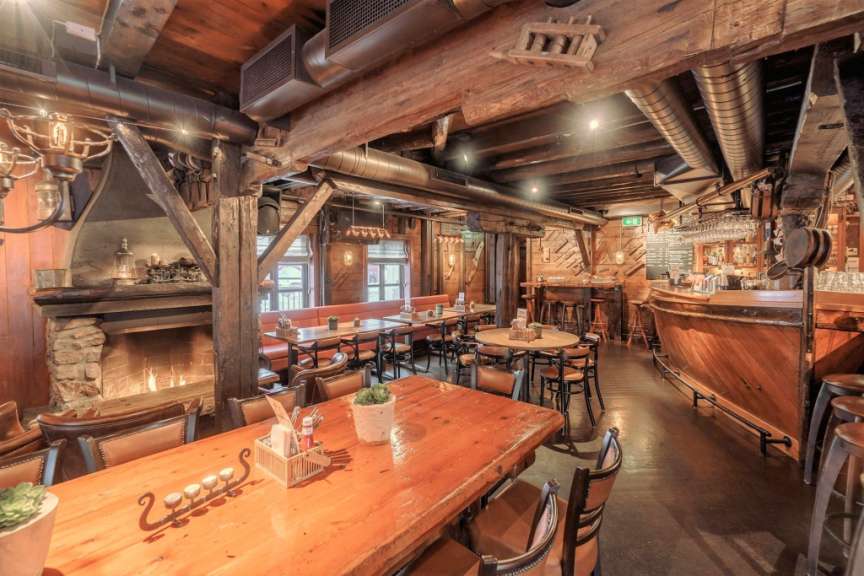 Ein Restaurant mit einem Tisch und Stühlen und einem Kamin