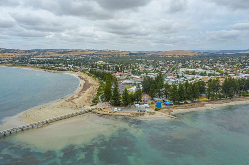 Ein Strand mit einem Pier und einer Stadt im Hintergrund