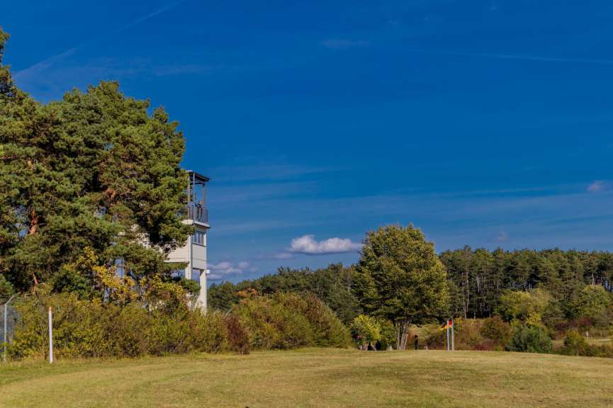 Ein weißes Gebäude auf einem Hügel mit Bäumen im Hintergrund