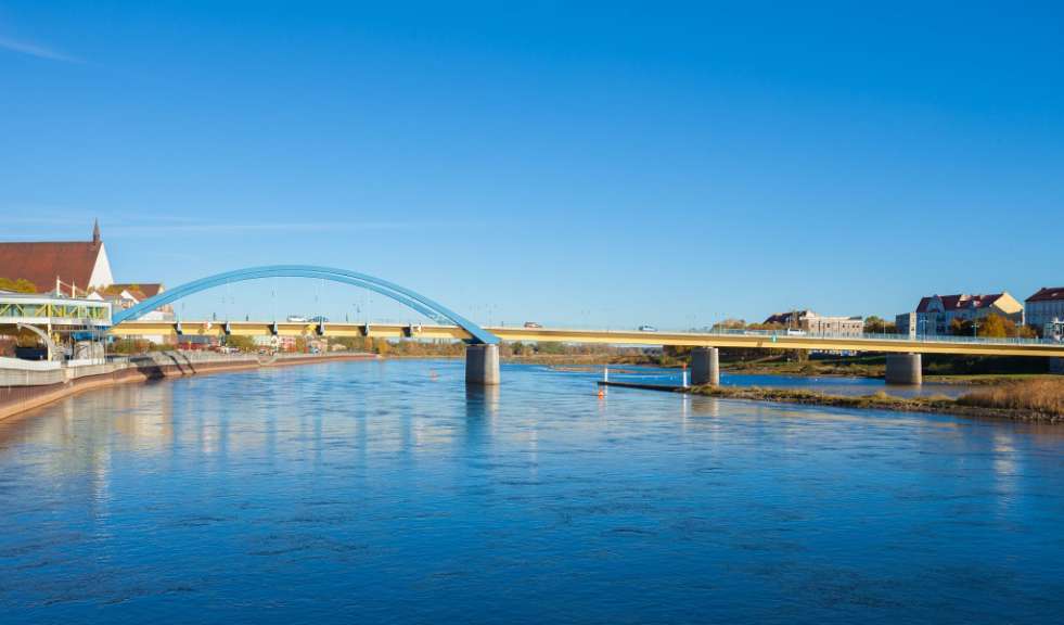 Eine blaue und gelbe Brücke über einen Fluss