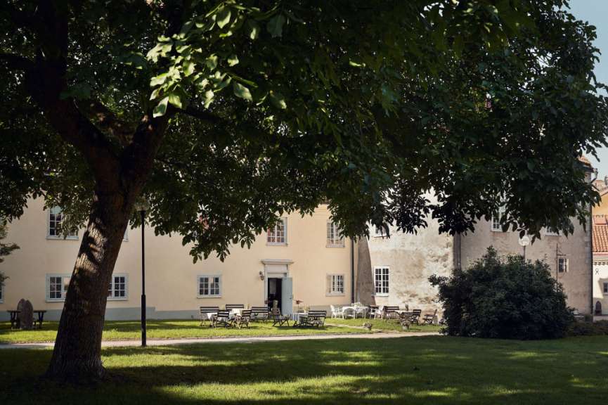 Ein Baum steht vor einem Gebäude mit Tisch und Stühlen
