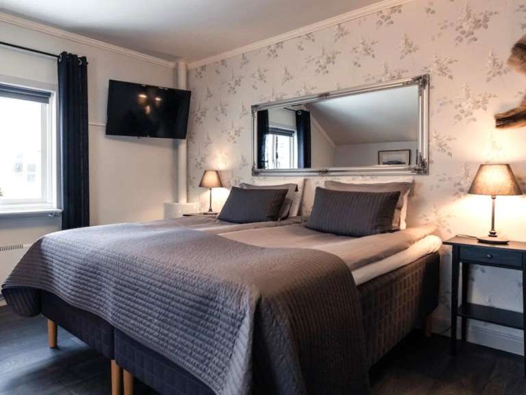 Ein Schlafzimmer mit zwei Betten und einem Fernseher