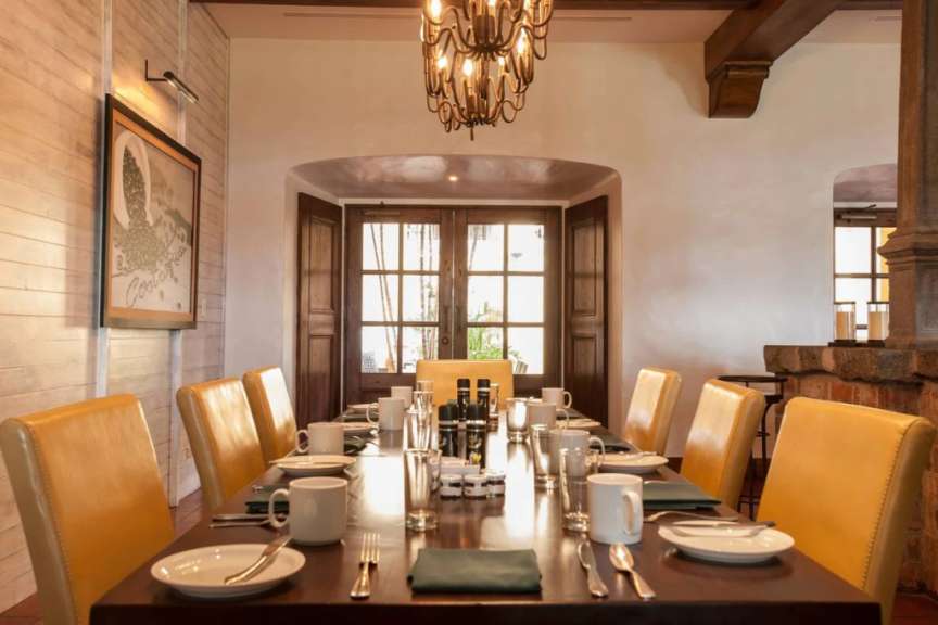 Ein Esszimmer mit einem langen Tisch und gelben Stühlen