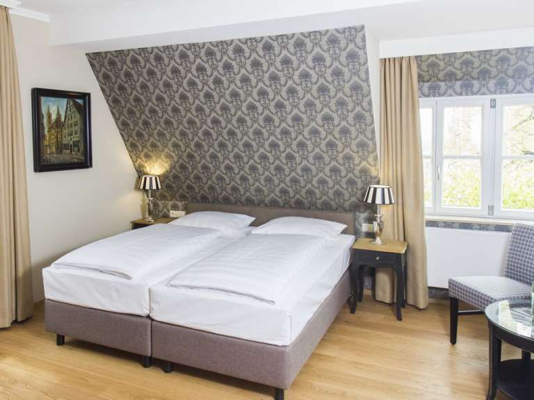 Ein Hotelzimmer mit zwei Betten und zwei Lampen