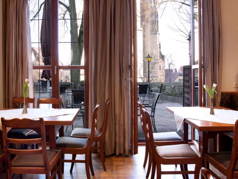 Tische und Stühle in einem Restaurant mit Blick auf eine Kirche