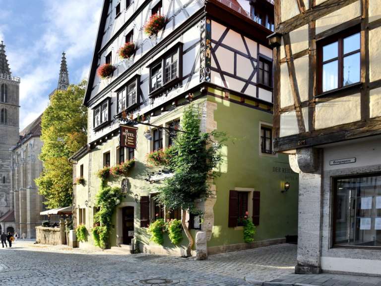 Ein grünes Gebäude mit einem Schild an der Seite, das sagt „ hotel “