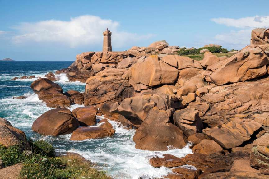 Ein Leuchtturm steht auf einem felsigen Hügel in der Nähe des Ozeans