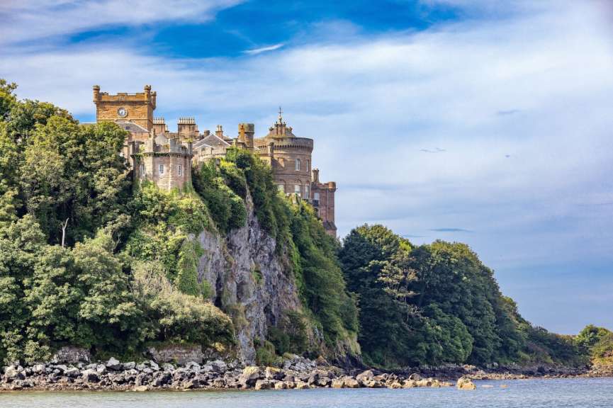 Ein großes Schloss sitzt auf einer Klippe über dem Wasser