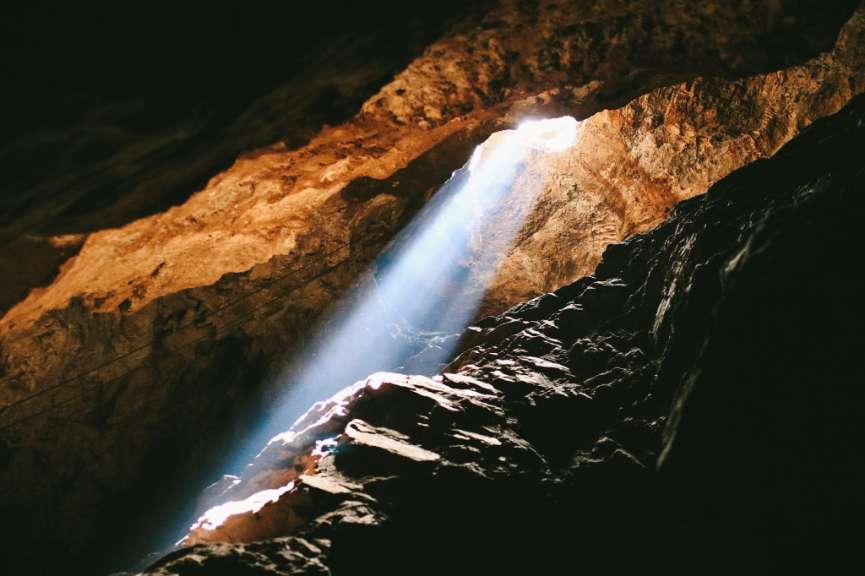 Licht scheint aus einem Loch in einer Höhle