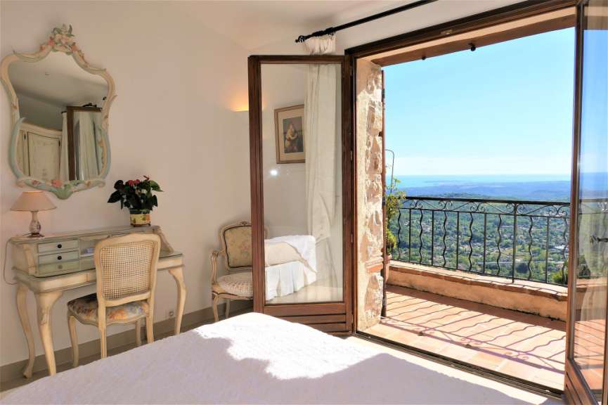 Ein Schlafzimmer mit Blick auf eine Landschaft und das Meer.