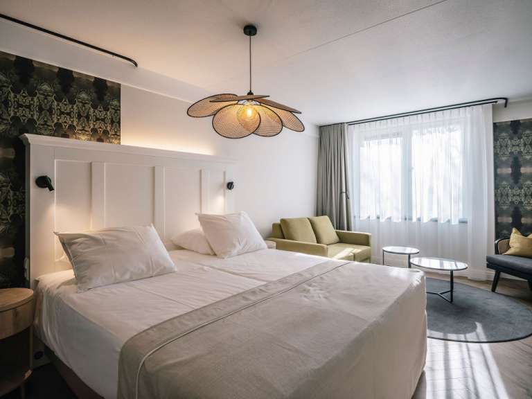 Ein Hotelzimmer mit einem Bett und einem Sessel