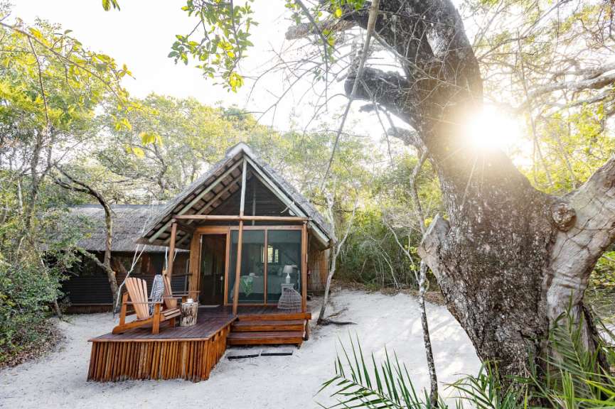 Ein kleines Holzhaus auf einem sandigen Strand