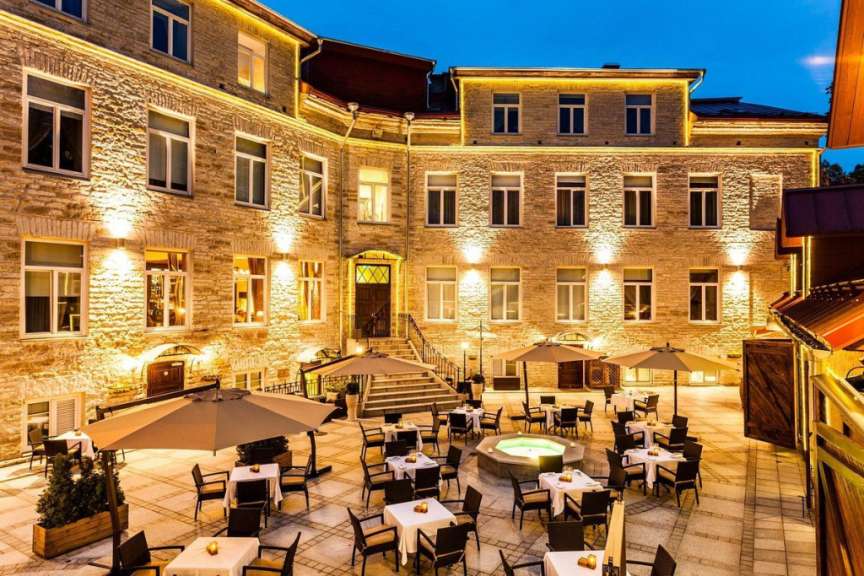 Ein Gebäude mit vielen Tischen und Stühlen davor