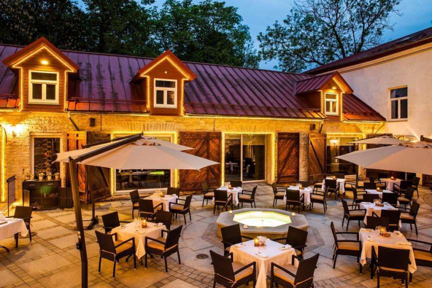 Eine Terrasse mit Tisch und Stühlen und Sonnenschirmen