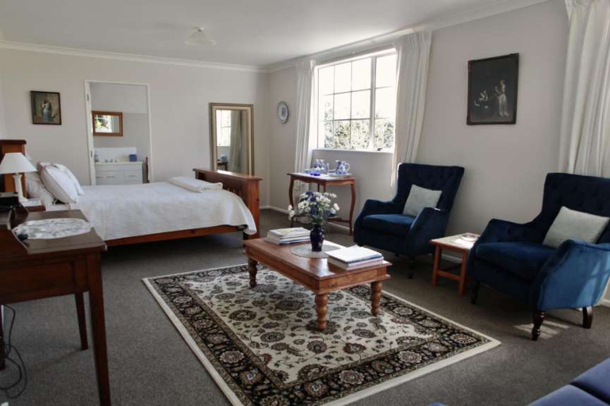 Ein Wohnzimmer mit einem Bett und zwei Stühlen