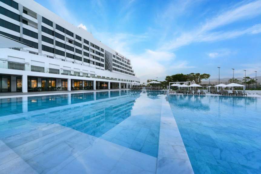 Ein großer Swimmingpool in der Nähe eines großen weißen Gebäudes