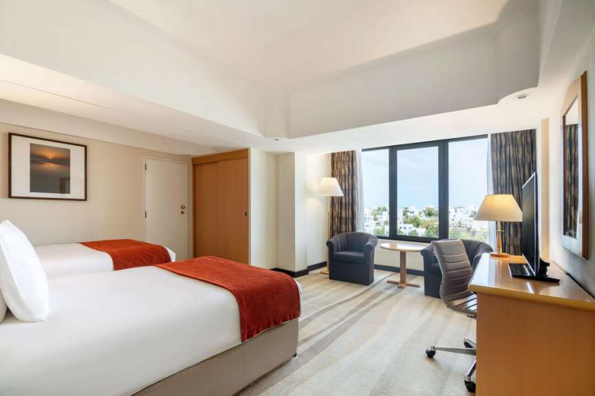 Ein Hotelzimmer mit zwei Betten und einem Schreibtisch