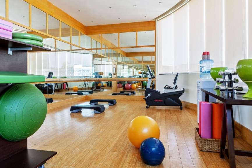 Ein Fitnessstudio mit vielen Bällen und einem Laufrad