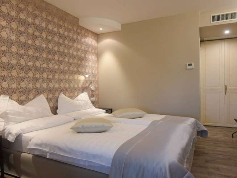 Ein Hotelzimmer mit einem Bett und einer Wandtapete