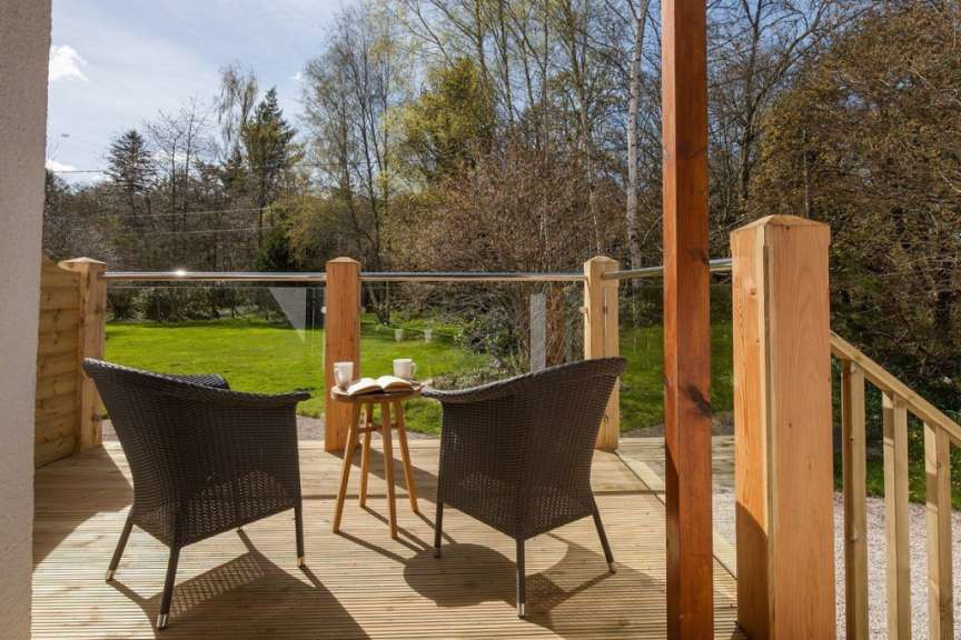 Zwei Stühle und ein Tisch auf einer Terrasse mit einem Buch auf dem Tisch