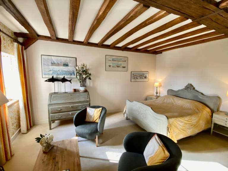 Ein Schlafzimmer mit einem Bett und zwei Stühlen