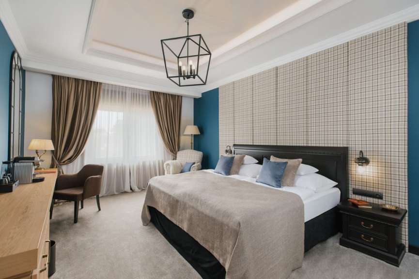 Ein Schlafzimmer mit einem großen Bett, einem Schreibtisch und einem Sessel.