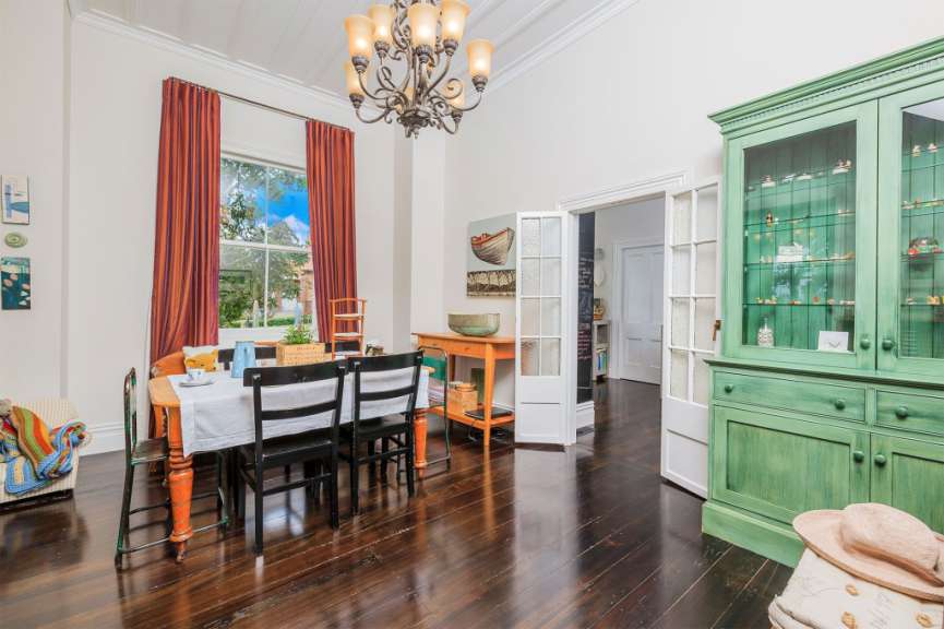 Ein Esszimmer mit einem Tisch und Stühlen und einem grünen Schrank
