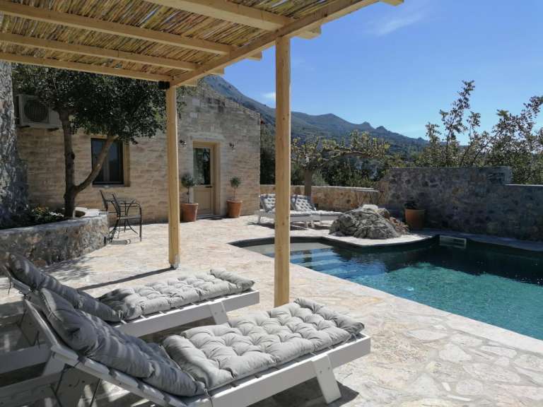 Liegestühle auf einer Terrasse neben einem Swimmingpool