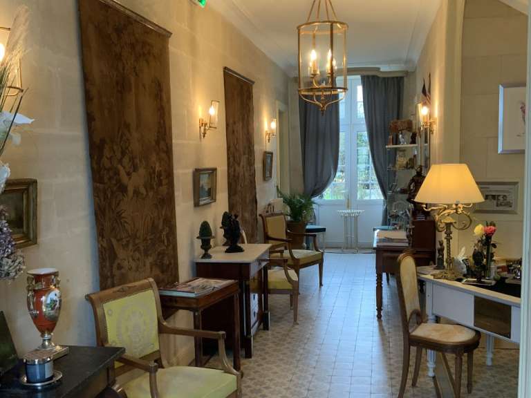 Ein langer Flur mit vielen Möbeln und Lampen