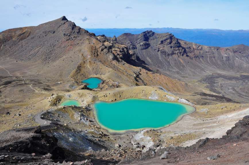 Eine Landschaft mit zwei kleinen Teichen und einem Berg im Hintergrund