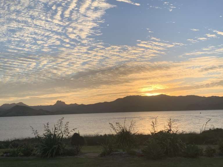 Ein Sonnenuntergang über einem See mit Bergen im Hintergrund