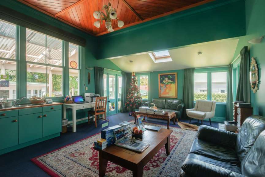 Ein Wohnzimmer mit grünen Wänden und einem Weihnachtsbaum
