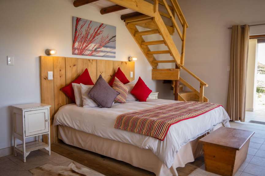 Ein Schlafzimmer mit einem Bett und einer Holztreppe