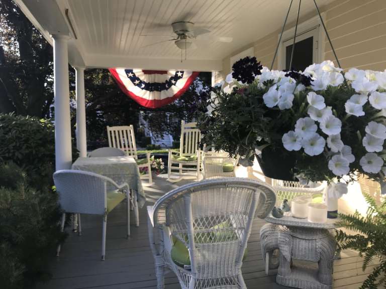 Eine Veranda mit Tisch und Stühlen und einem amerikanischen Flagge