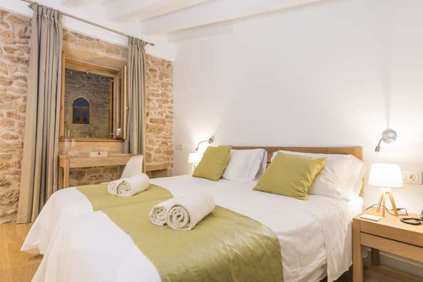 Ein Schlafzimmer mit weißen Betten und grünen Kissen