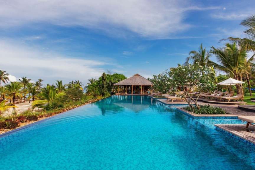 Ein riesiger Pool mit Liegestühlen und Palmen umgeben