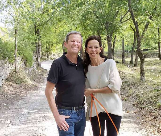 Ein Mann und eine Frau stehen auf einem Feldweg und lächeln
