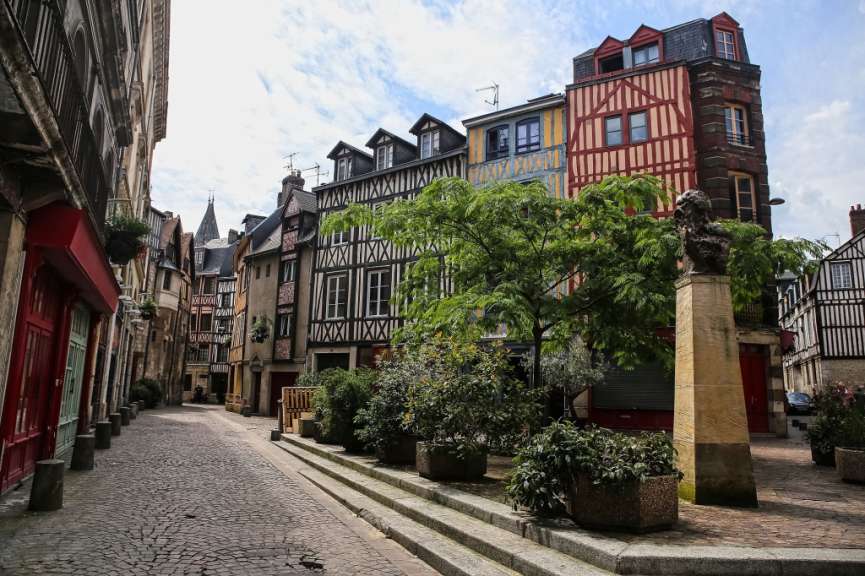 Eine kleine Straße mit vielen Gebäuden und einer Statue