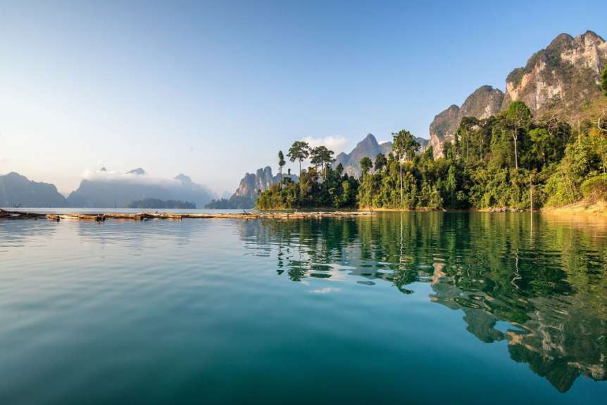 Ein See mit Bäumen und Bergen im Hintergrund