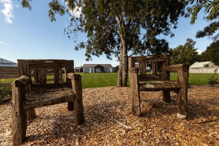 Ein paar Holzstühle sitzen auf einem Haufen Holzchips
